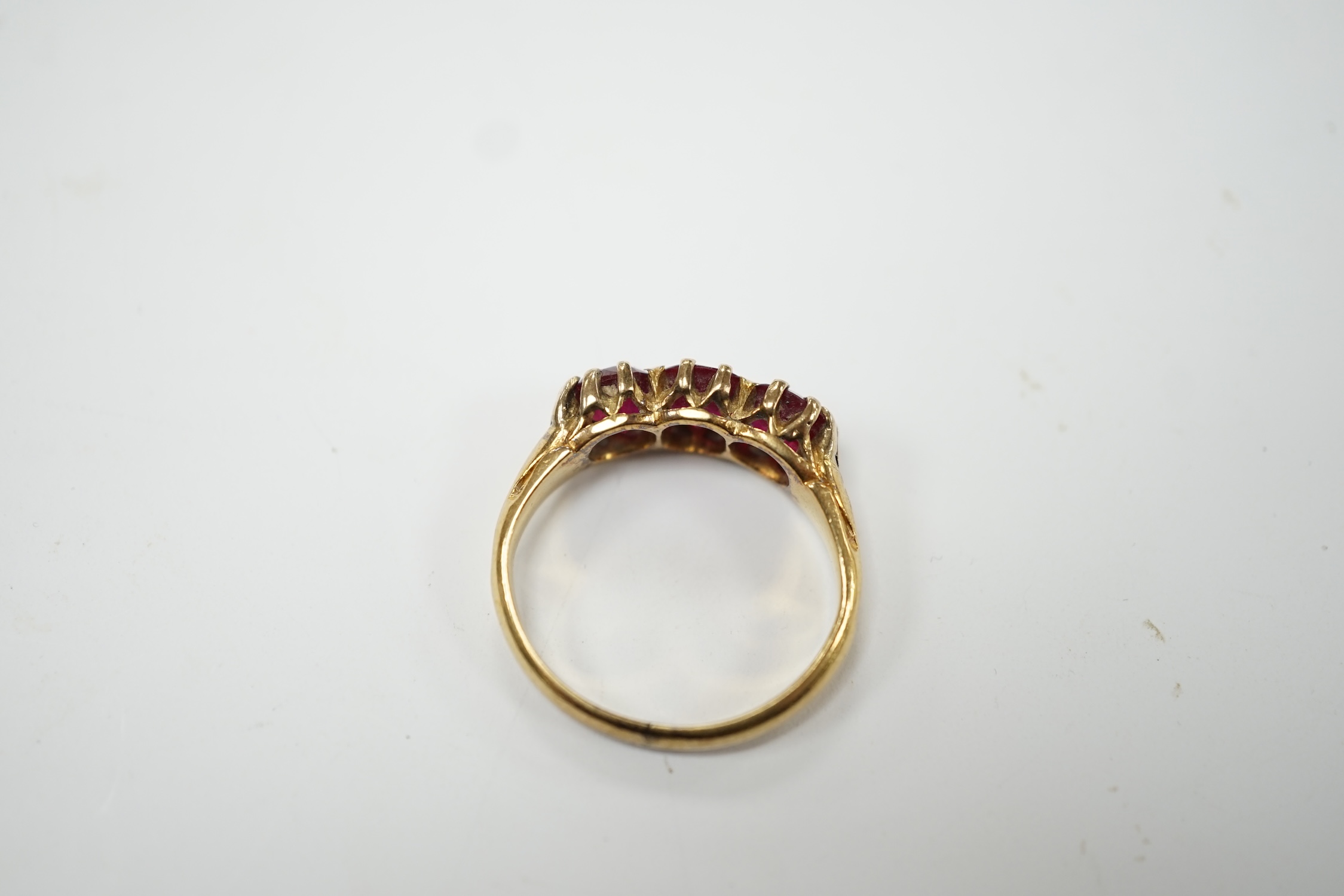 A yellow metal and three stone synthetic ruby set ring, size M, gross weight 4.8 grams. Condition - fair